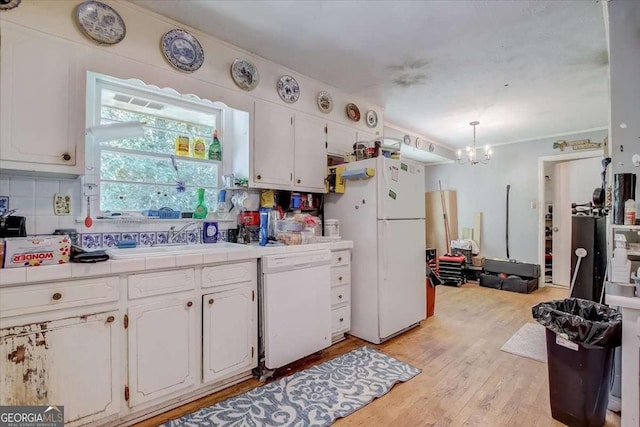 kitchen featuring white cabinetry, white appliances, decorative light fixtures, and sink