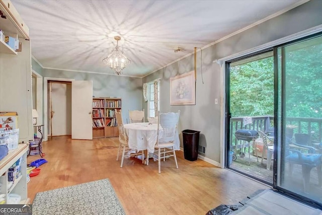 dining area with crown molding, light hardwood / wood-style floors, and a chandelier