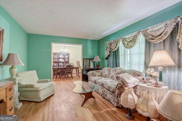 living room featuring a chandelier and light wood-type flooring