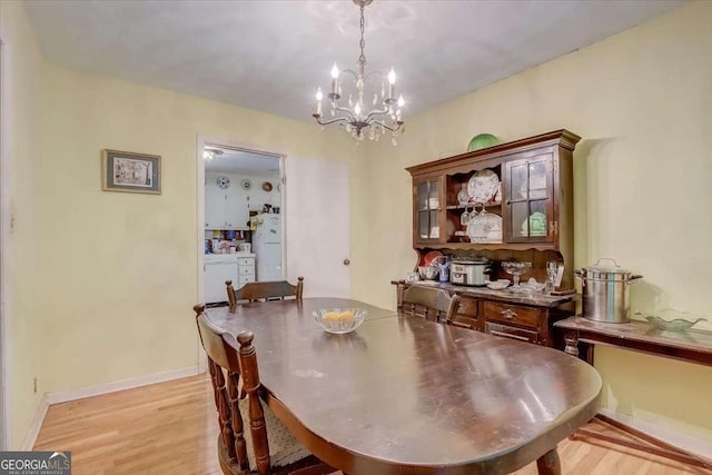 dining space with a notable chandelier and light hardwood / wood-style floors