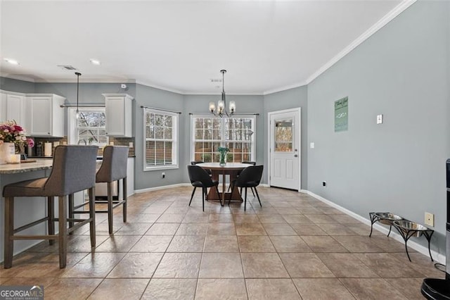 dining room with ornamental molding, tile patterned flooring, and a notable chandelier