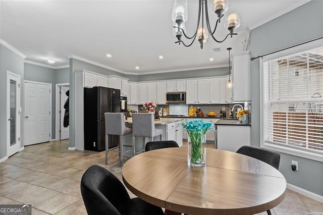 tiled dining room with sink, plenty of natural light, and ornamental molding