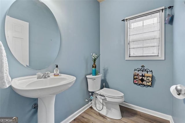 bathroom featuring wood-type flooring and toilet