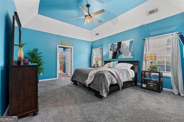 bedroom with ceiling fan, lofted ceiling, a tray ceiling, and carpet floors