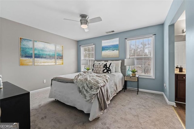 carpeted bedroom with ceiling fan and ensuite bath