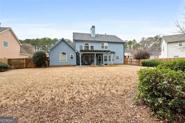 rear view of house with a lawn and a pergola