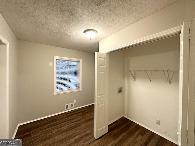 laundry area featuring dark hardwood / wood-style flooring, hookup for a washing machine, and a textured ceiling