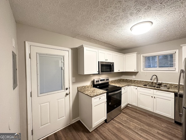 kitchen featuring white cabinetry, appliances with stainless steel finishes, sink, and dark stone countertops