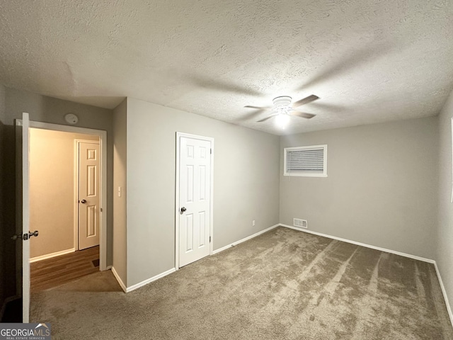 unfurnished bedroom with a textured ceiling, ceiling fan, and carpet