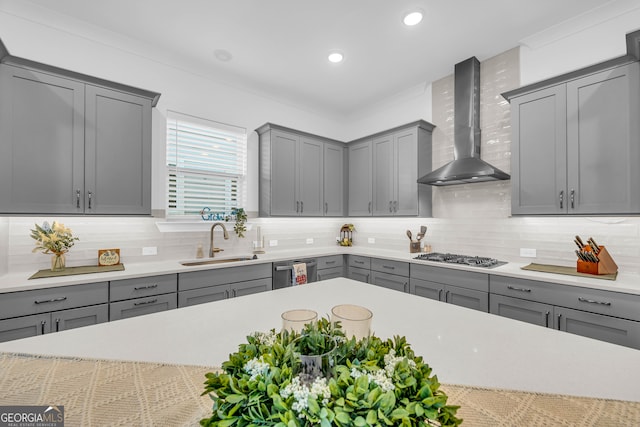 kitchen featuring gray cabinetry, appliances with stainless steel finishes, sink, and wall chimney range hood