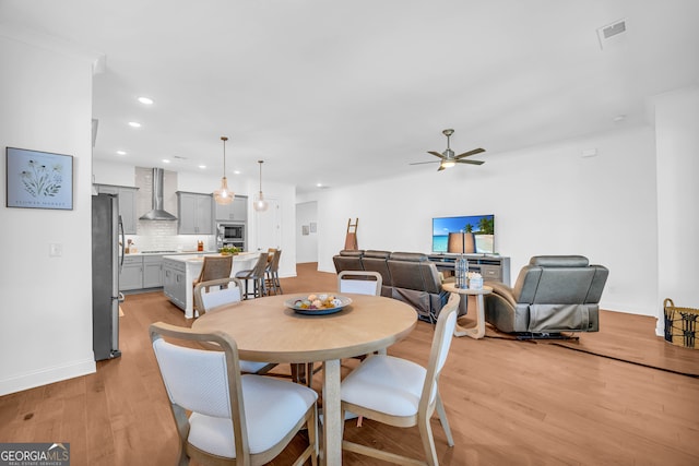 dining room with ceiling fan and light wood-type flooring