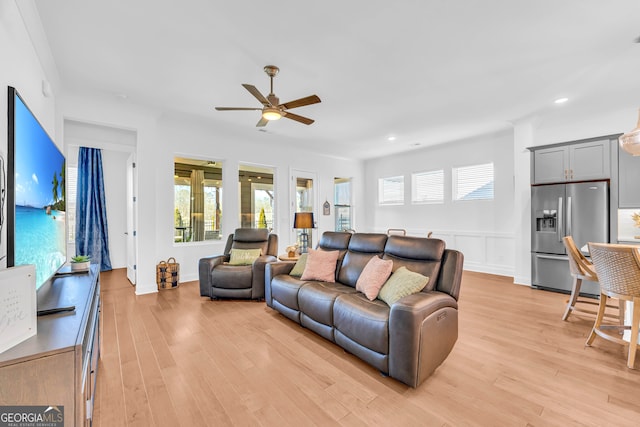 living room with ceiling fan and light wood-type flooring