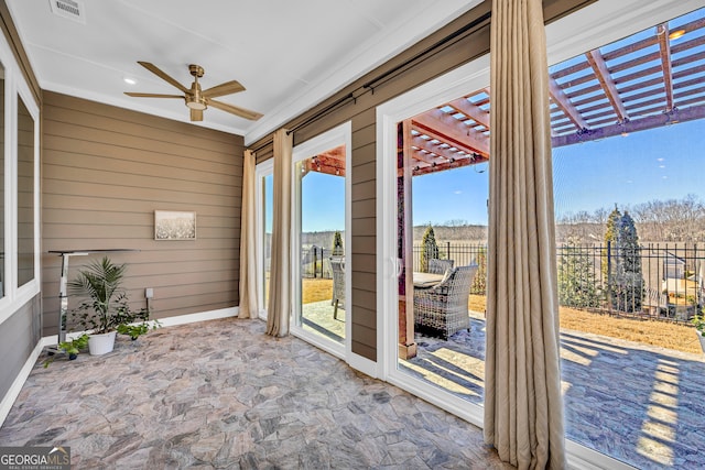 unfurnished sunroom featuring ceiling fan