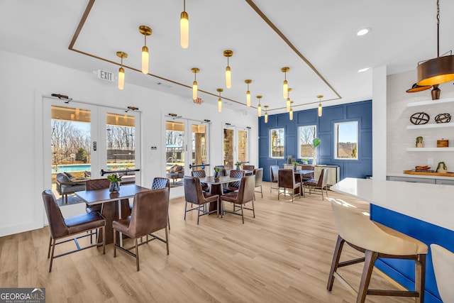 dining room with french doors, plenty of natural light, and light hardwood / wood-style flooring