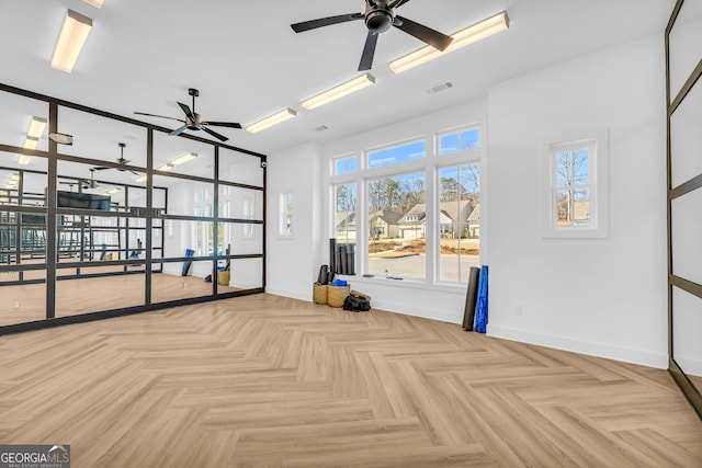 empty room with ceiling fan and light parquet floors