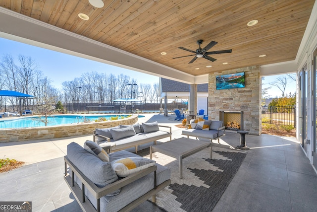 view of patio / terrace with a community pool and an outdoor living space with a fireplace