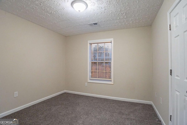 carpeted empty room with a textured ceiling