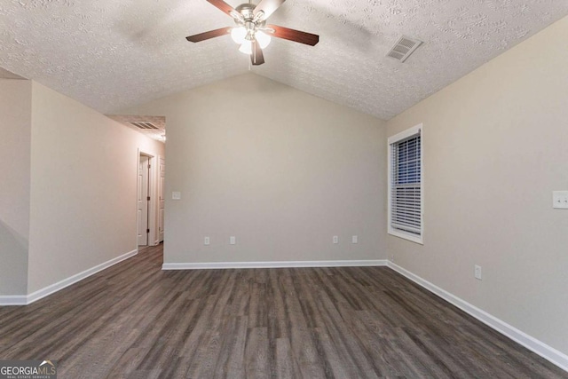 spare room with ceiling fan, lofted ceiling, dark hardwood / wood-style floors, and a textured ceiling