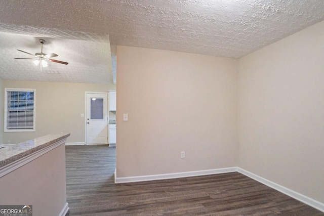 empty room with ceiling fan, a textured ceiling, and dark hardwood / wood-style flooring