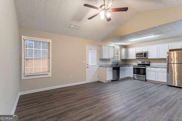 kitchen with white cabinetry, stainless steel appliances, dark hardwood / wood-style floors, and a textured ceiling