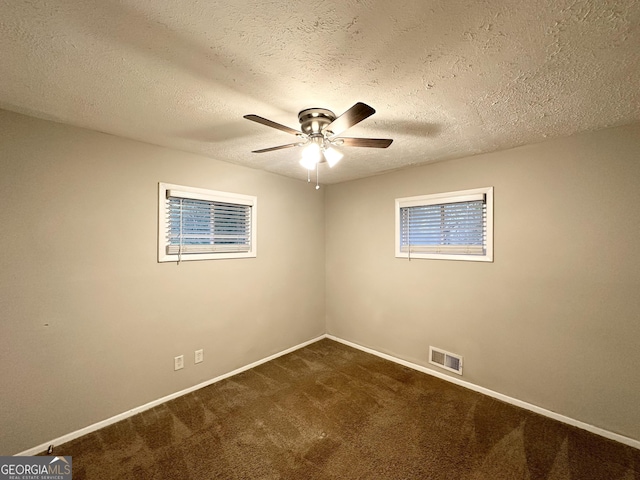 unfurnished room with ceiling fan, a textured ceiling, and dark colored carpet