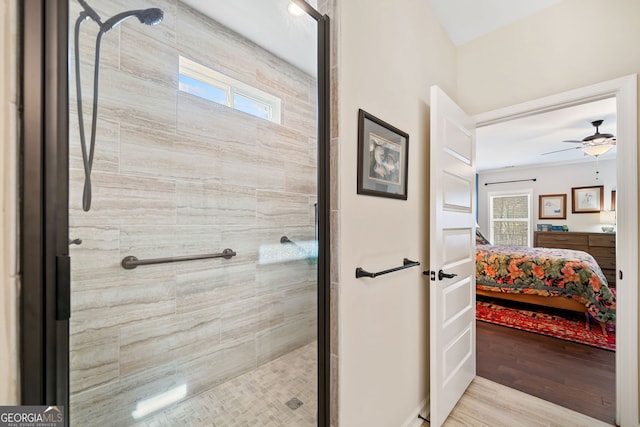 full bath with ceiling fan, tiled shower, wood finished floors, and ensuite bath