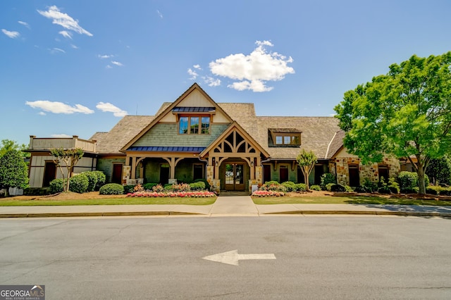 view of front of property with a standing seam roof, french doors, and stone siding