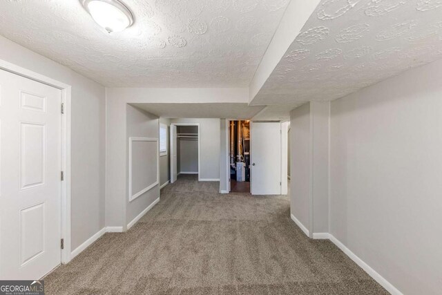 hall featuring light carpet and a textured ceiling