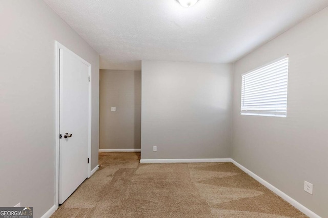 unfurnished room with light carpet and a textured ceiling