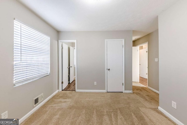 unfurnished bedroom with light colored carpet