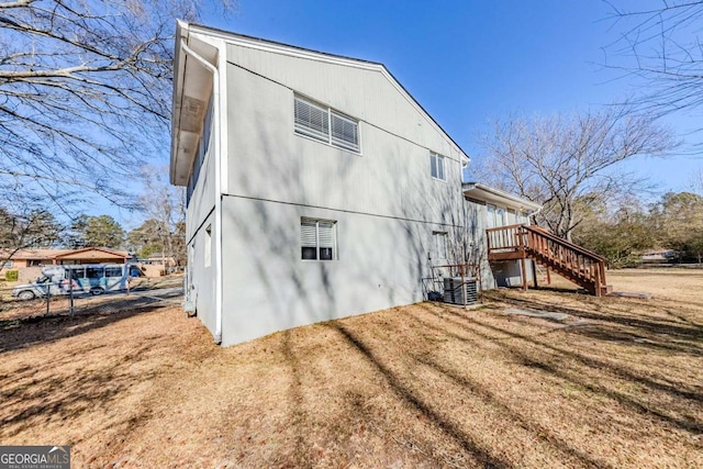 view of side of home with central AC and a yard