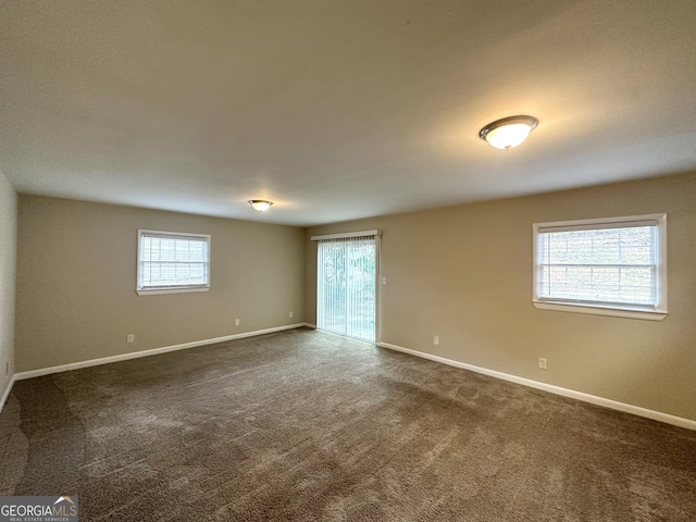 spare room featuring dark carpet