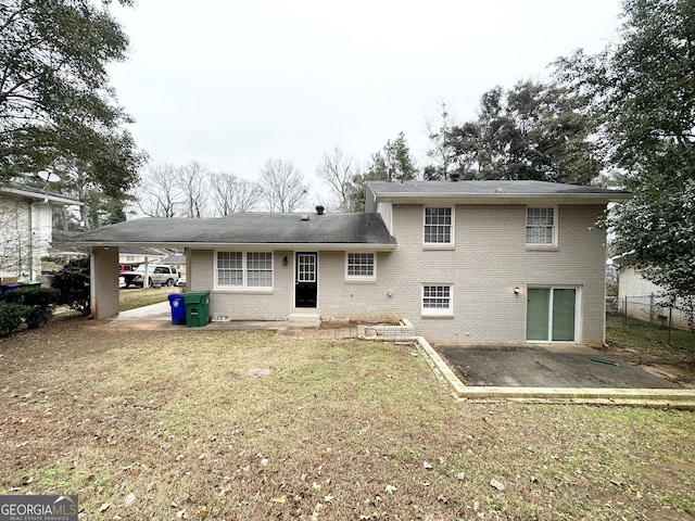 rear view of house featuring a lawn and a patio