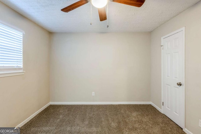 empty room featuring ceiling fan, a textured ceiling, and carpet