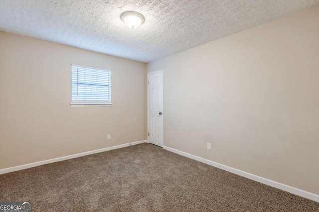 empty room featuring carpet and a textured ceiling