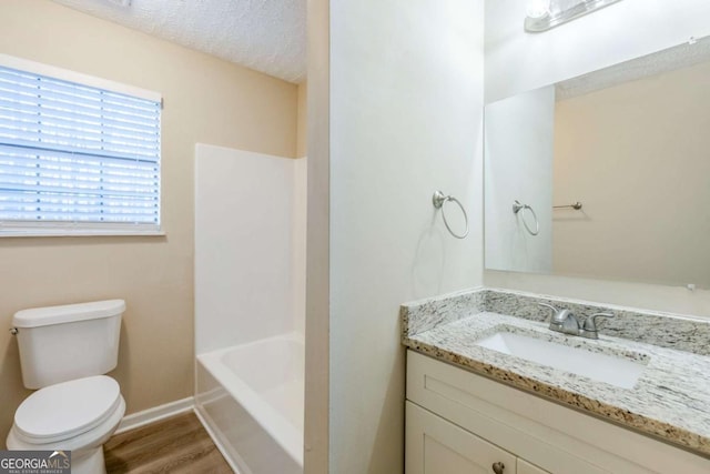 full bathroom featuring shower / bathing tub combination, wood-type flooring, vanity, toilet, and a textured ceiling