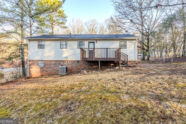 back of property with cooling unit, a wooden deck, and a yard