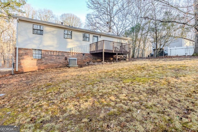 rear view of house featuring cooling unit, a yard, and a deck