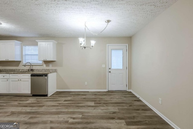 kitchen with hardwood / wood-style flooring, stainless steel dishwasher, and white cabinets