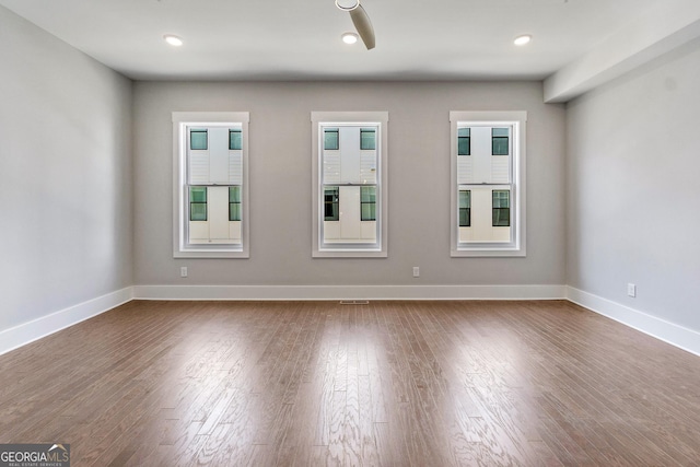 spare room with dark wood-style floors, baseboards, and recessed lighting