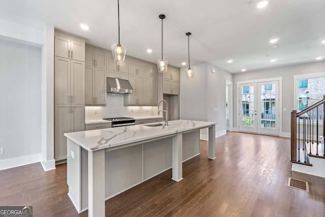 kitchen featuring french doors, visible vents, backsplash, a sink, and under cabinet range hood