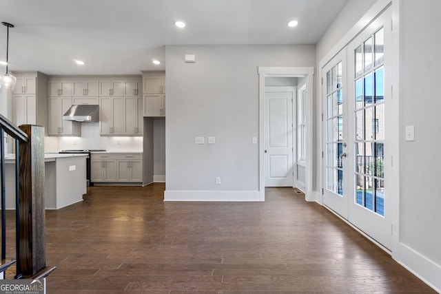 kitchen with dark wood-type flooring, gray cabinetry, stainless steel range, and decorative light fixtures