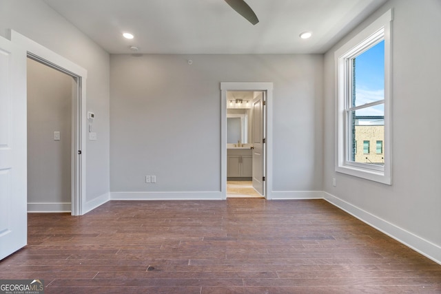 unfurnished bedroom with ceiling fan, sink, connected bathroom, and dark hardwood / wood-style flooring