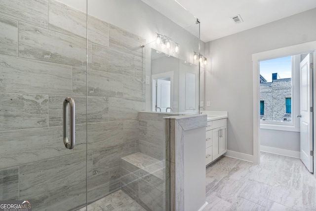 bathroom with a shower with door, vanity, and a wealth of natural light