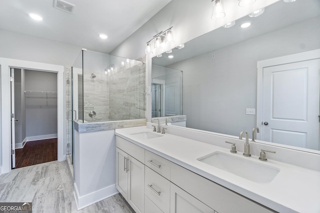 bathroom with walk in shower, vanity, and hardwood / wood-style flooring