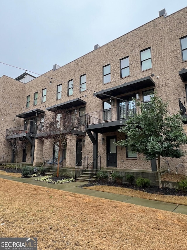 view of property featuring brick siding and a front yard