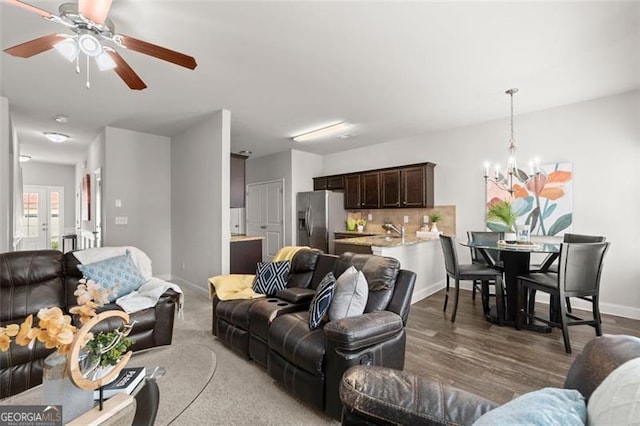 living room featuring ceiling fan with notable chandelier, french doors, and dark hardwood / wood-style flooring