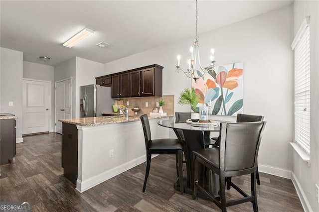 dining area featuring a chandelier and dark hardwood / wood-style floors