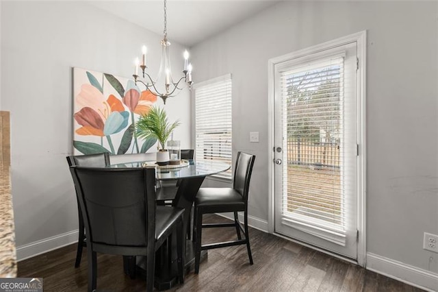 dining area featuring dark wood-type flooring and a notable chandelier