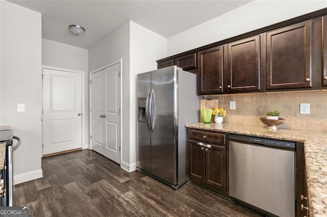 kitchen with appliances with stainless steel finishes, dark brown cabinetry, dark wood-type flooring, and light stone counters